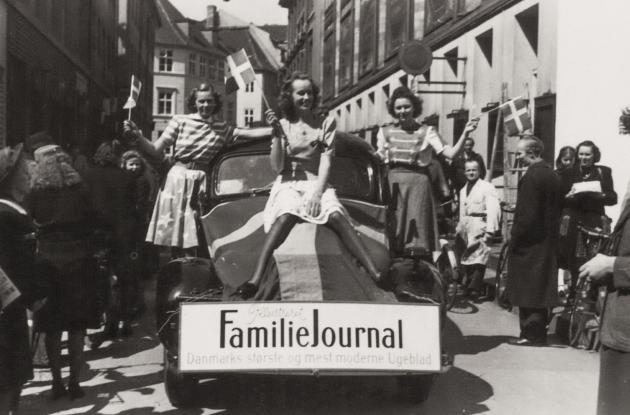 Ruth Gjersøe gør reklame for Familie Journalen 1945, siddende på køleren af en bil