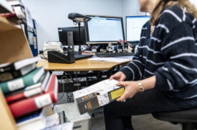 Person tager bøger fra en bogvogn